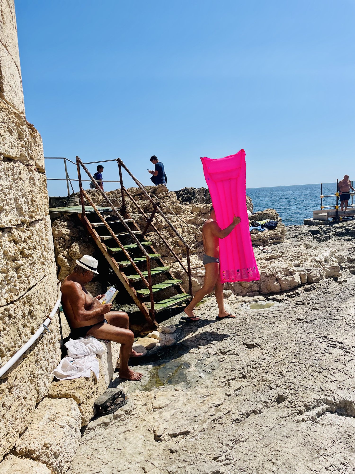 Homme portant un matelas gonflable rose, Méditerranée